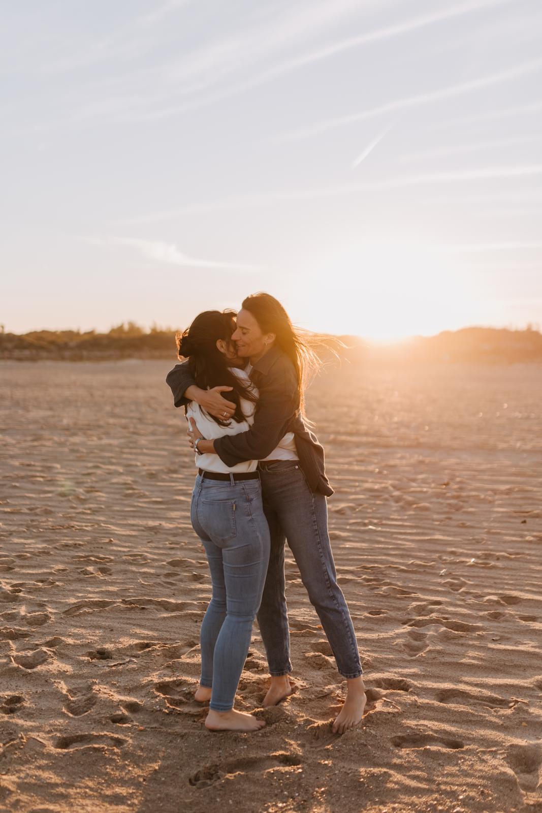 Las novias se abrazan en la playa al atardecer